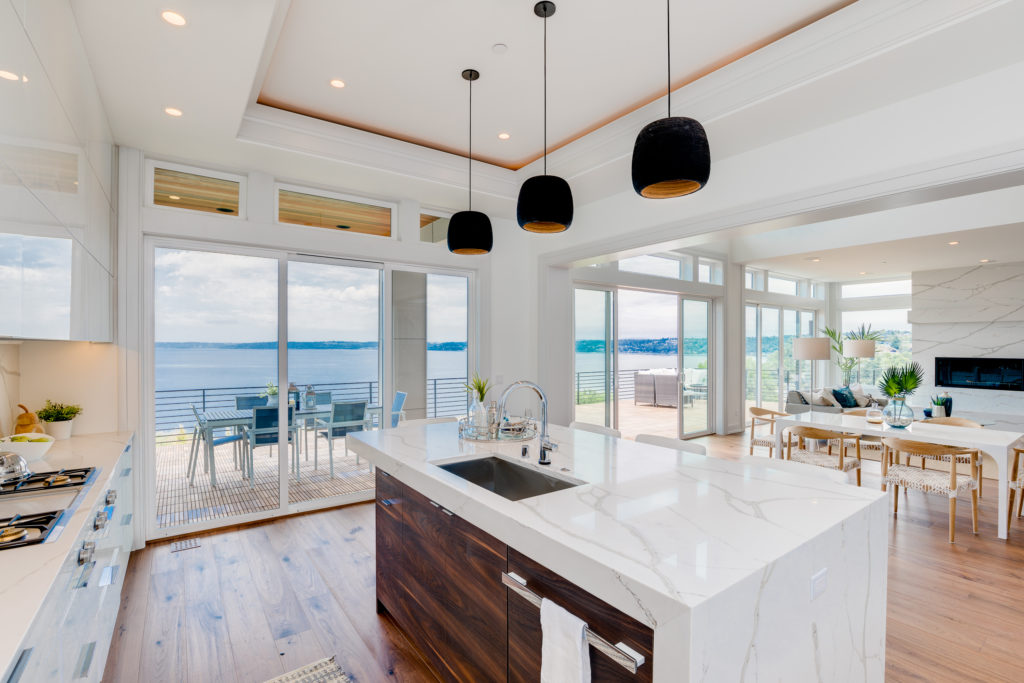 Luxury custom kitchen with large island and ceiling to floor windows of balcony