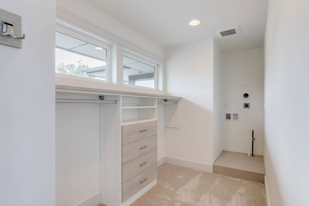 Luxury walk-in closet with washer and dryer stacked
